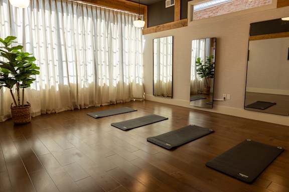 A room with wooden floors and a mirror on the wall.