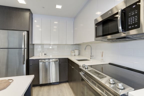 a kitchen with white cabinets and stainless steel appliances  at 1405 Point, Maryland, 21231