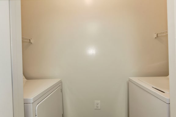 an empty laundry room with a washer and dryer and a sink at County Center Crossing Apartments in Woodbridge, VA