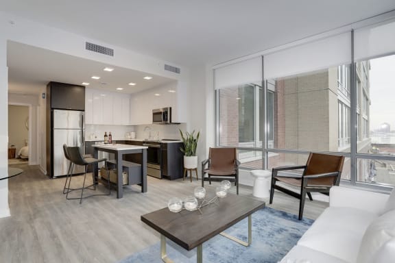 a living area with a couch coffee table and chairs and a kitchen with a breakfast bar  at 1405 Point, Baltimore