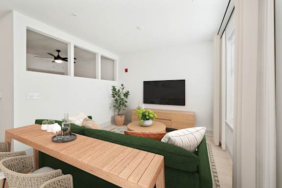 A modern living room with a green couch and a wooden table.