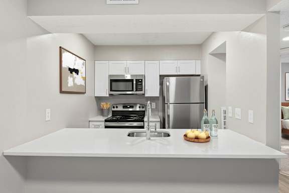 A modern kitchen with a stainless steel refrigerator and a white countertop at Brampton Moors, Cary, NC