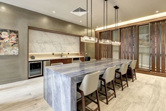 a large kitchen with a marble counter top and a long table at Highgate at the Mile, McLean, VA 22102