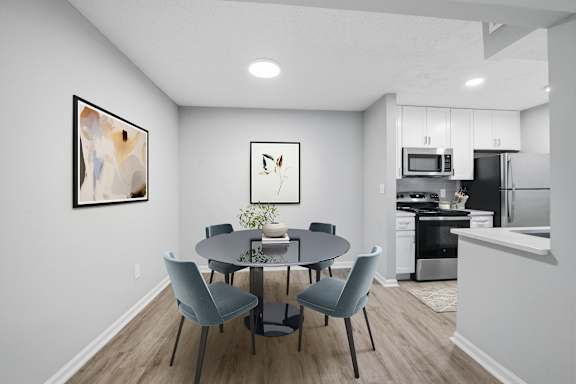 A modern dining room with a round table and grey chairs at Brampton Moors, Cary, NC