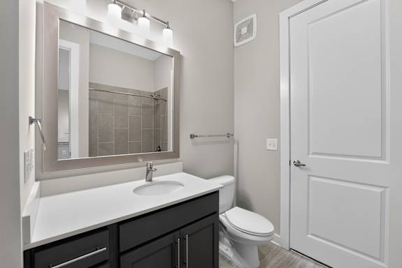A bathroom with a white sink and a white toilet.