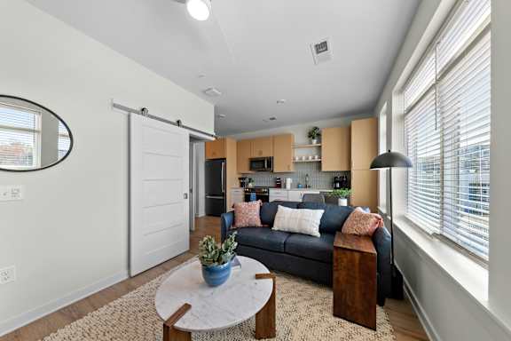 A modern living room with a black couch and a coffee table at Hawkins Press Apartments, North Carolina, 28203