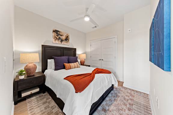 A bedroom with a large bed and a ceiling fan at Hawkins Press Apartments, Charlotte
