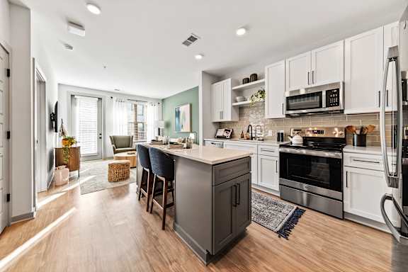 A modern kitchen with a large island and stainless steel appliances.