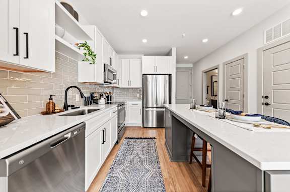 A modern kitchen with white cabinets and a stainless steel dishwasher.