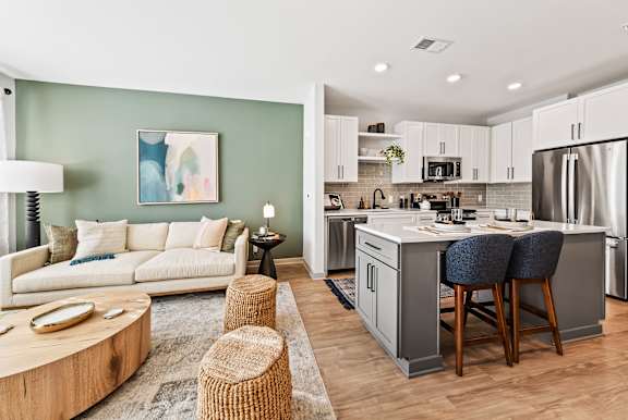 A modern kitchen with a breakfast bar and a living room area.