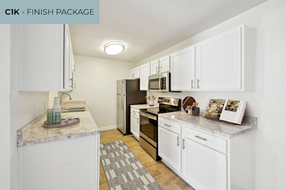 A kitchen with white cabinets and a granite countertop.