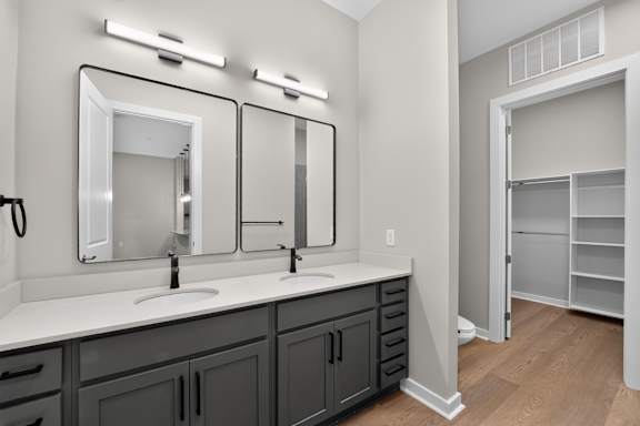 A bathroom with two sinks and a large mirror.