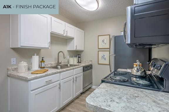 A kitchen with white cabinets and a black stove top oven.