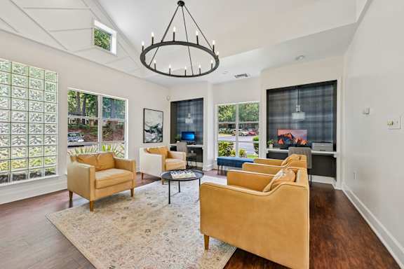 A living room with a tan couch and a chandelier.