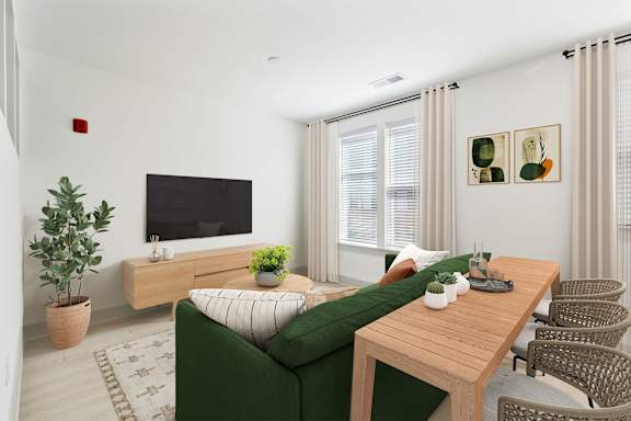A living room with a green couch, a wooden table, and a television.