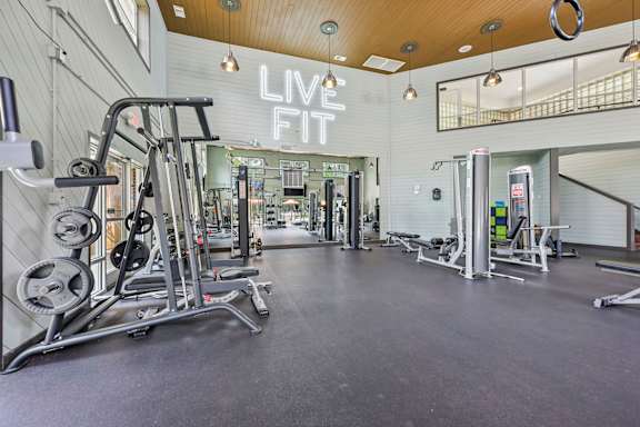 A gym with a variety of equipment and a sign that says "LIVE FIT".