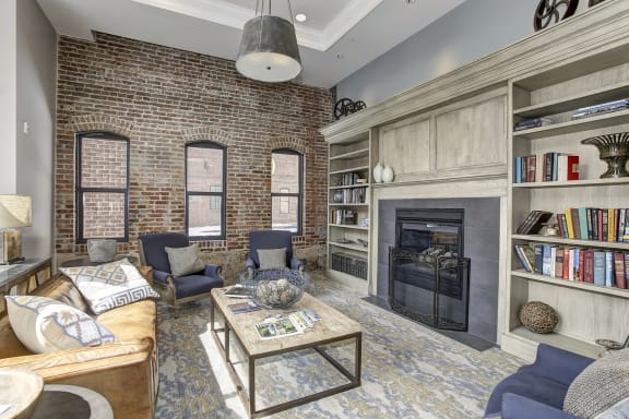 a living room with a brick wall and a fireplace at The Gunther, Baltimore, MD