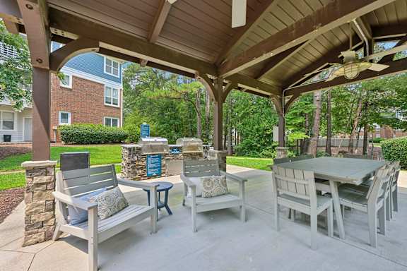 A patio with a table and chairs under a roof.
