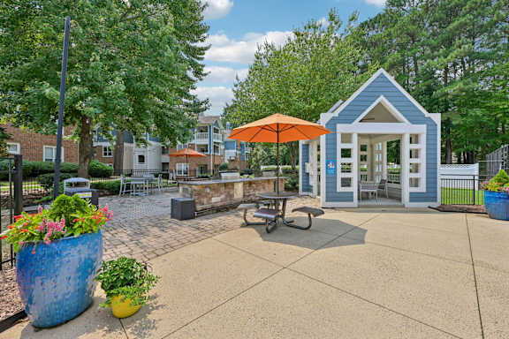 A blue and white building with an orange umbrella sits in the middle of a courtyard.