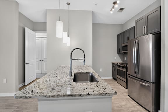 A modern kitchen with granite countertops and stainless steel appliances.