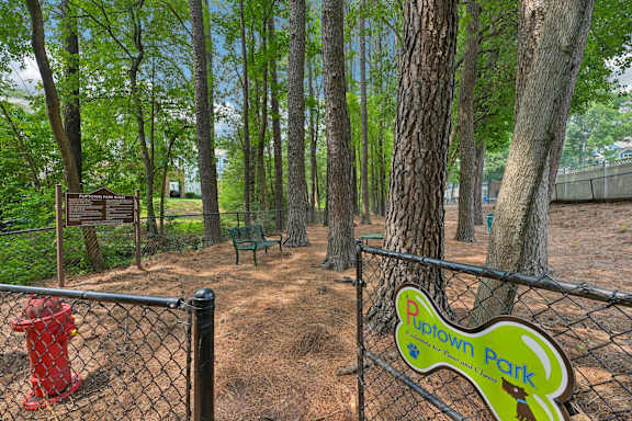 A sign for Rupown Park is on a fence in front of a tree.