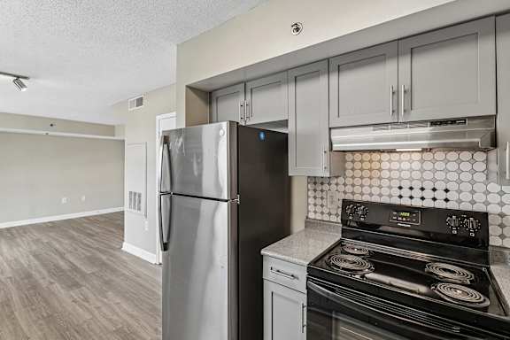 A kitchen with a black stove top oven and a black refrigerator.