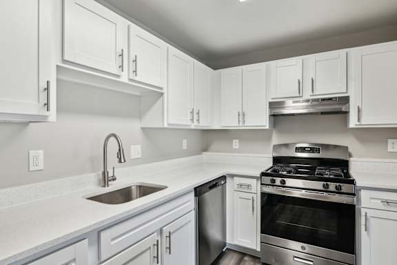 A kitchen with white cabinets and stainless steel appliances.