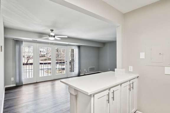 A kitchen with white cabinets and a ceiling fan.