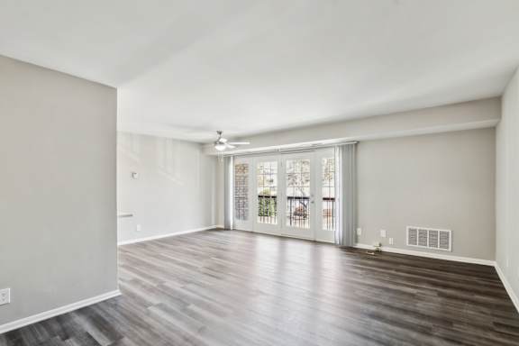 A room with wooden flooring and a sliding glass door.