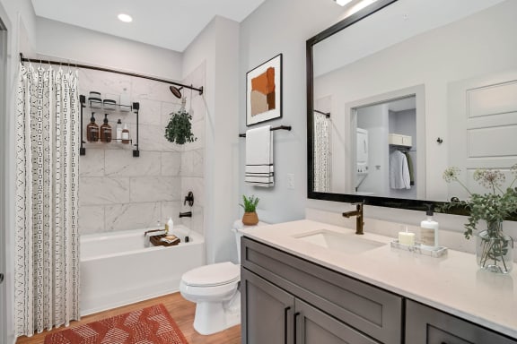 a bathroom with a large mirror and a sink and a toilet