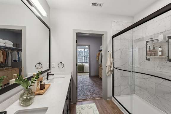 A bathroom with a marble countertop and a walk-in shower.