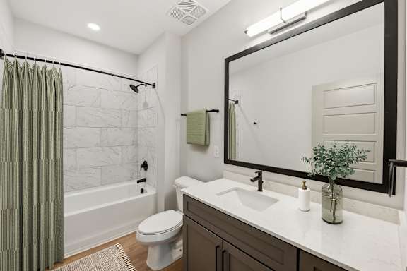 A bathroom with a white toilet, a white sink, and a green shower curtain.