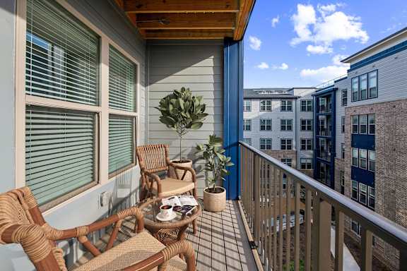 A balcony with a table and chairs.