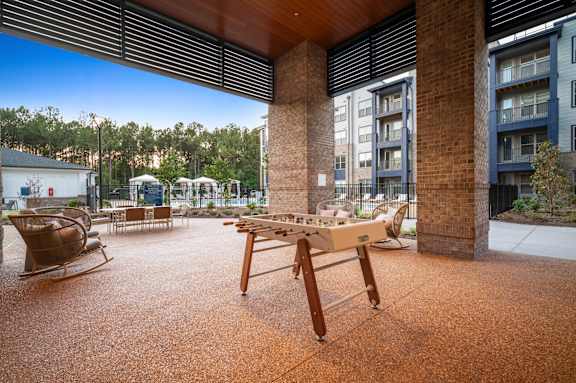 A wooden table is in the middle of a courtyard.