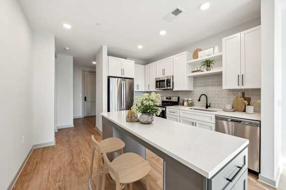 A kitchen with white cabinets and a white countertop.