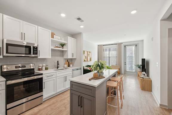 A modern kitchen with white cabinets and stainless steel appliances.