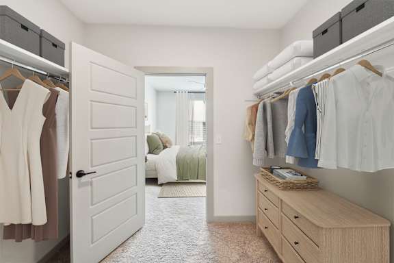 A bedroom with a white door and a wardrobe with clothes hanging on it.