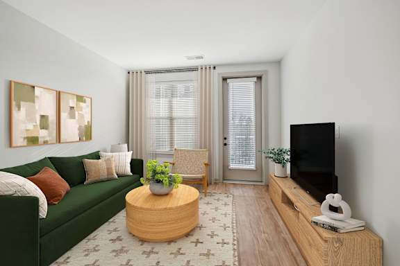A living room with a green couch, a wooden coffee table, and a flat screen TV.