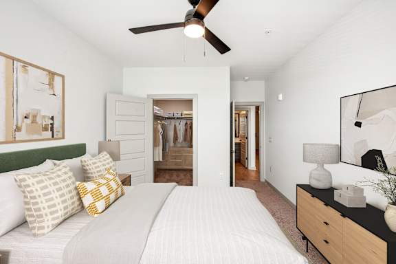 A bedroom with a large bed and a ceiling fan.