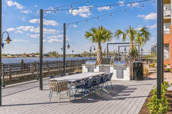 a patio with a table and chairs and a bar and a body of water at the Riverwalk, Wilmington, North Carolina