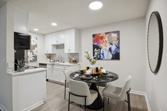 our apartments offer a dining room and kitchen with white cabinets and appliances at St. Andrews Reserve, Wilmington, NC