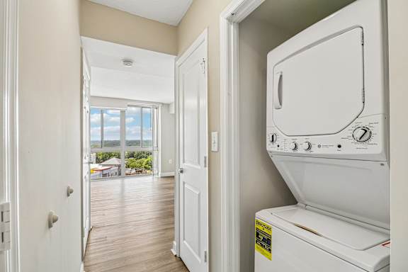 A white dryer is sitting in a laundry room next to a door.
