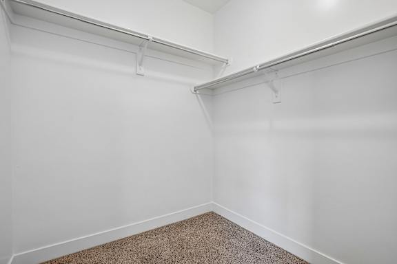 A white wall with a brown carpet on the floor.