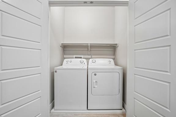 A white toilet and sink in a small white room.