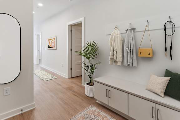 A room with a bench, coat rack, and a plant at Hawkins Press, Charlotte, North Carolina