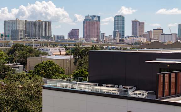 A cityscape with a modern building in the foreground. at Miles at Ybor Apartments, Tampa, FL