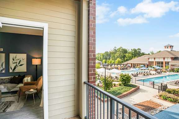 A balcony view of a pool area from a room.