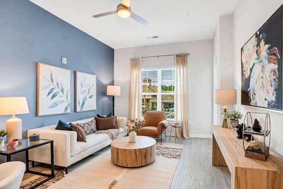 A living room with a white couch, a coffee table, and a painting on the wall.