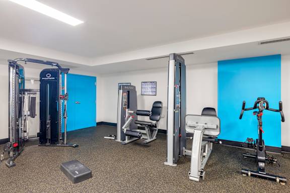 A gym with a variety of equipment including a treadmill, a stationary bike, a rowing machine, and a weight bench. at Loree Grand at Union Place, Washington, 20002