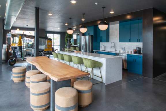A modern kitchen with a long wooden table and green chairs at Lotus Cityline Apartments, Salt Lake City, Utah